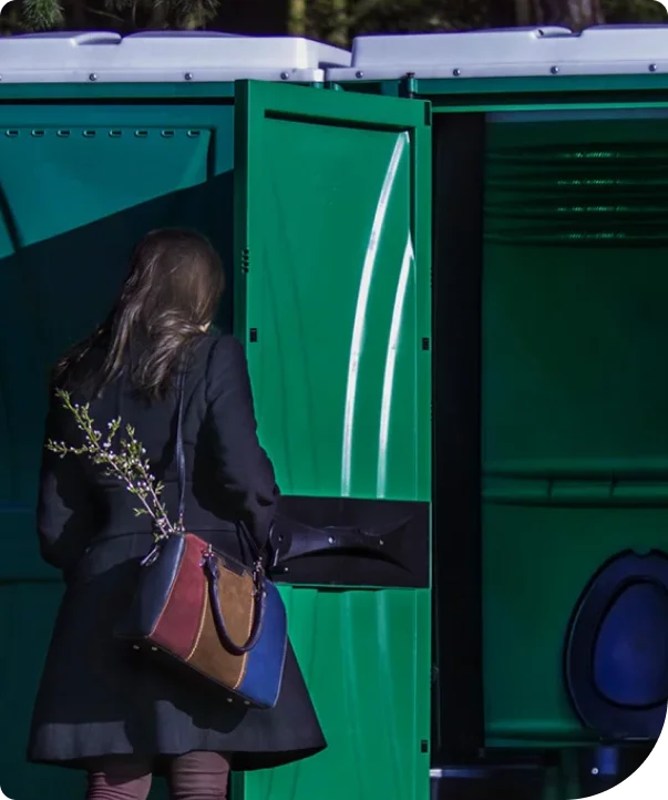 A guest entering a clean green Gotta Go Potties portable restroom